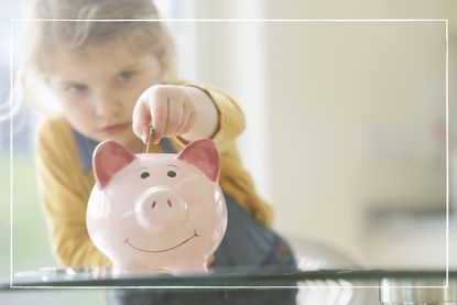 young girl putting coins into a piggy bank to illustrate good money saving habits