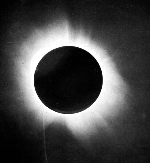 A positive print of the 1919 eclipse plate shows the Moon's black silhouette ringed by the Sun's bright corona flaring against a dark sky.