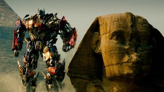 Still from the movie Transformers: Revenge of the Fallen (2009). Here we see the Transformer Optimus Prime (red and blue robot that can turn into a truck) standing next to a Sphynx in Egypt.