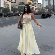 Influencer wears a yellow skirt.