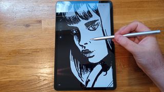 A photo of a person drawing on a digital tablet