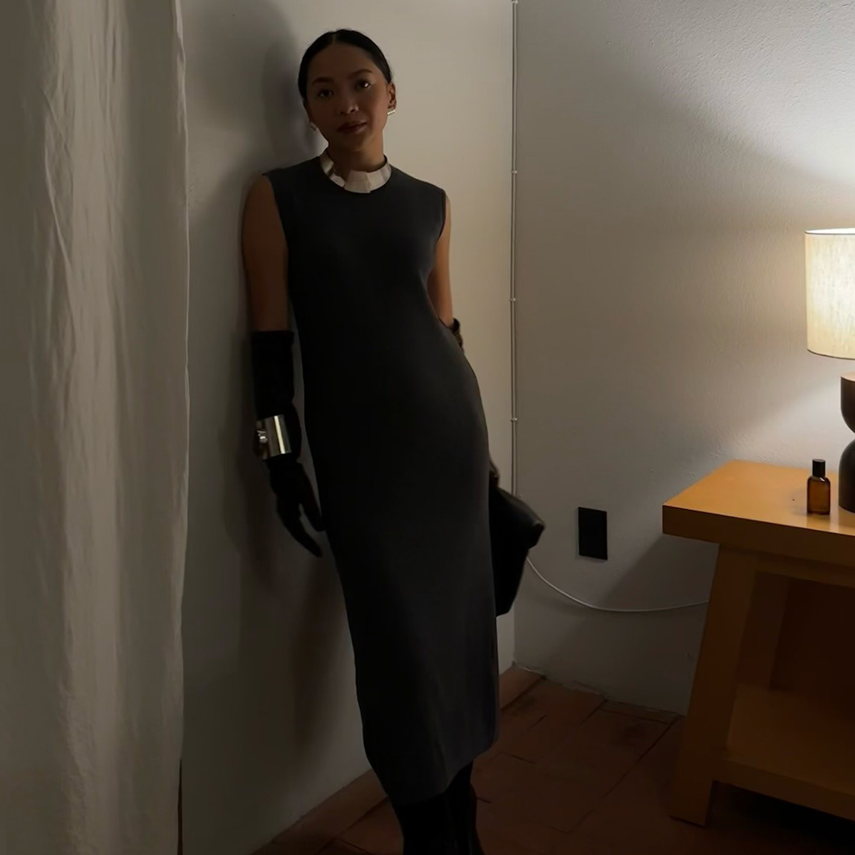 Dawn wears a grey knit dress with gloves and a silver necklace.