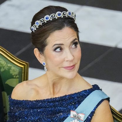 Queen Mary wearing a blue dress and sapphire tiara