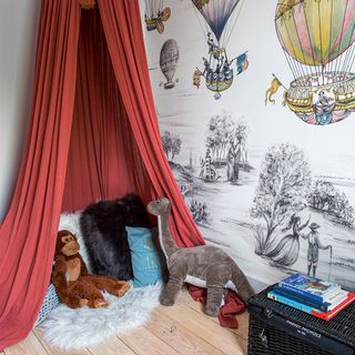 boys bedroom with balloon wallpaper and red canopy