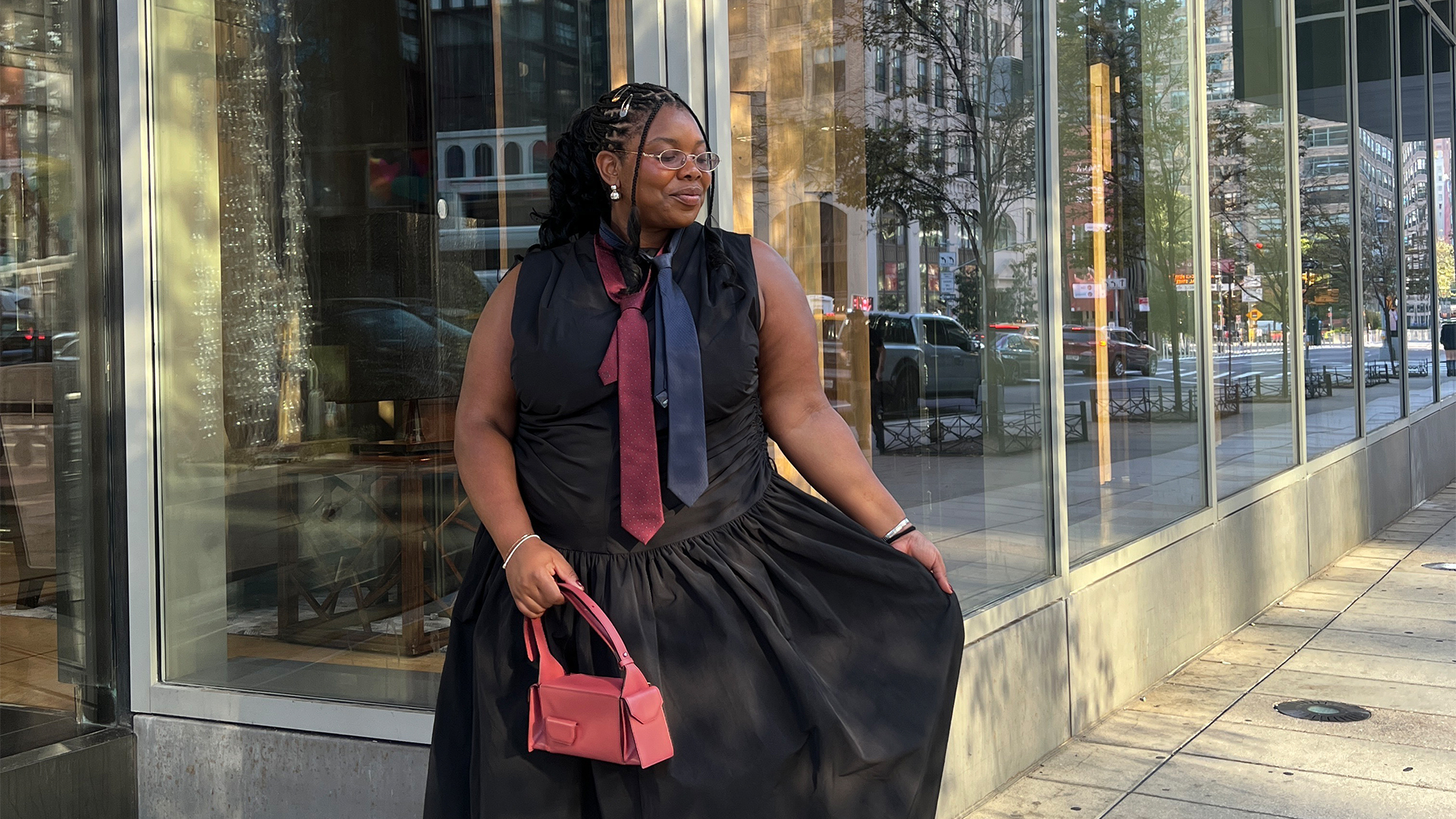 Chichi wears black dress with a blue and red tie and red handbag with two toned loafers and red socks.