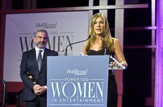 Jennifer Aniston accepts the Sherry Lansing Leadership Award from Steve Carell onstage at The Hollywood Reporter 2021 Power 100 Women in Entertainment.