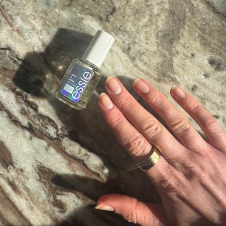 a close up of Eleanor's nails and the essie hard to resist nail polish bottle