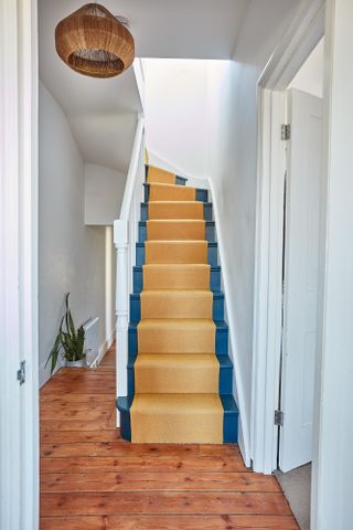 Lily Pickard house: dark blue painted staircase with yellow stair runner