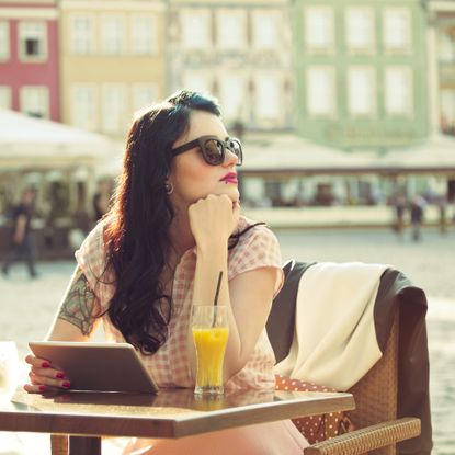 Young woman using a digital tablet in the outdoor restaurant