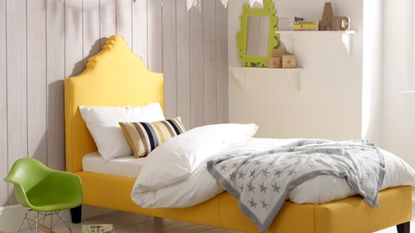 white bedroom with yellow bed and wooden flooring