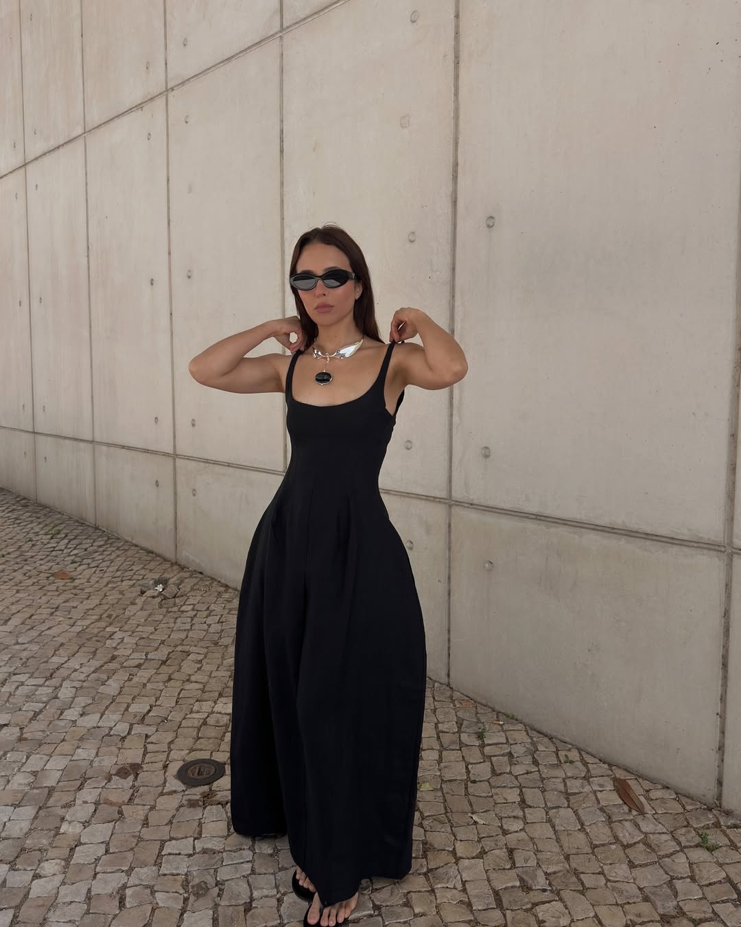 @deborabrosa wears a black dress and flip-flops