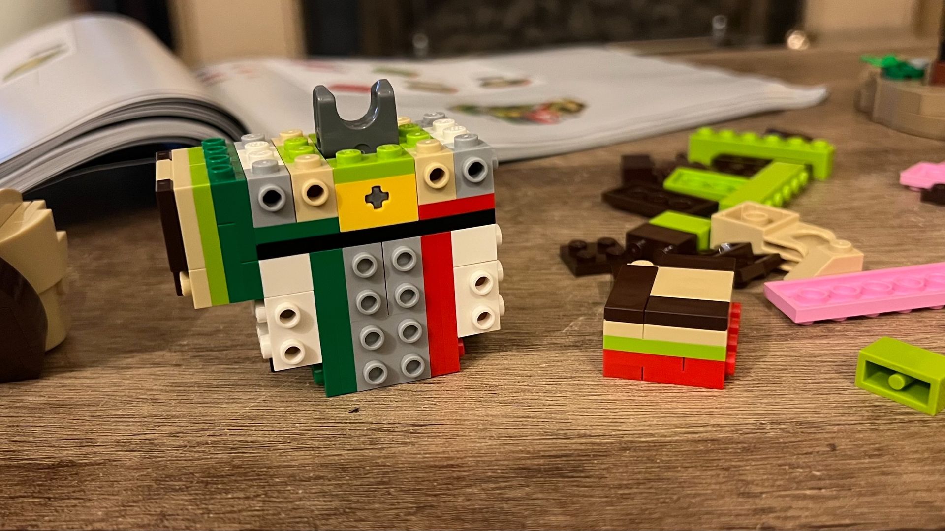 Bricks forming base of Lego Shrek structure on a wooden table
