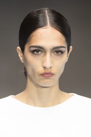 Model on the runway at Carolina Herrera wearing winged liner, a key Spring/Summer 2025 Fashion Month beauty look