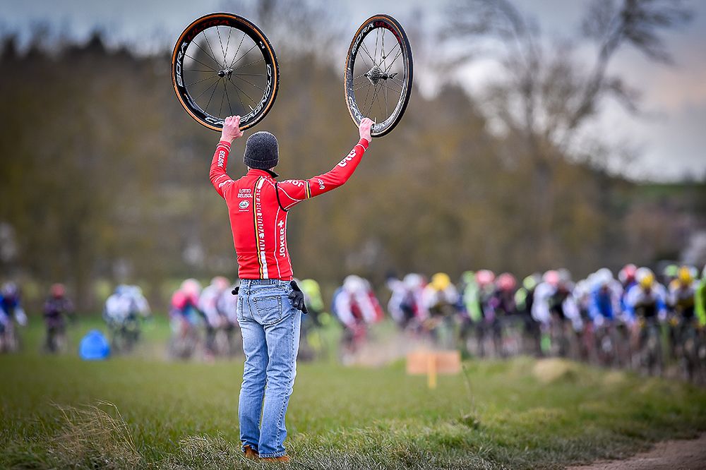 A team mechanic holds wheels for riders in the gravel section during stage 1 at Paris-Nice