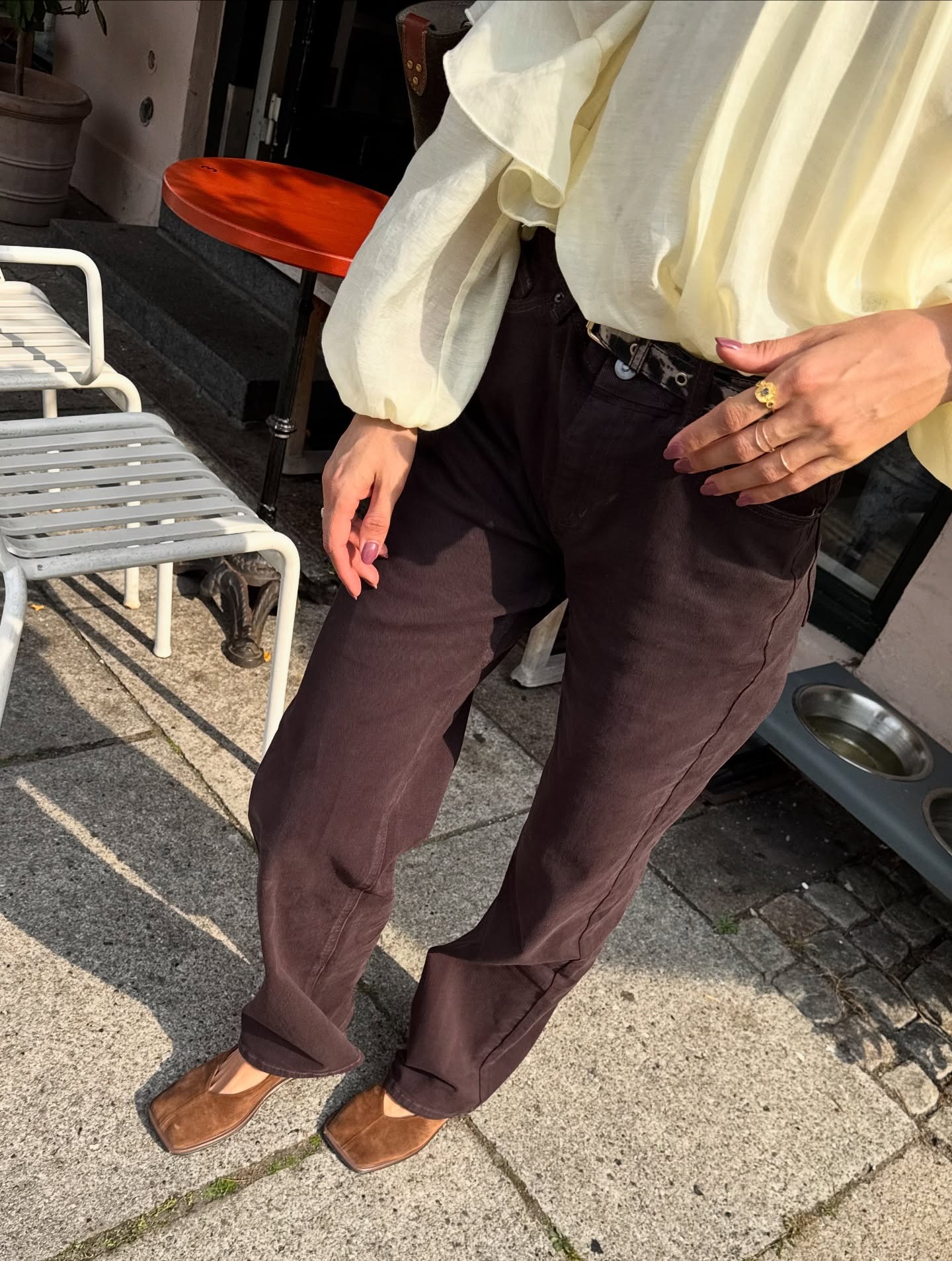 Influencer @josephinebredsted wears a butter yellow blouse with burgundy jeans and brown suede shoes.