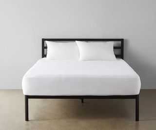The Amazon Basics Mattress Protector on a bed in a minimalist bedroom