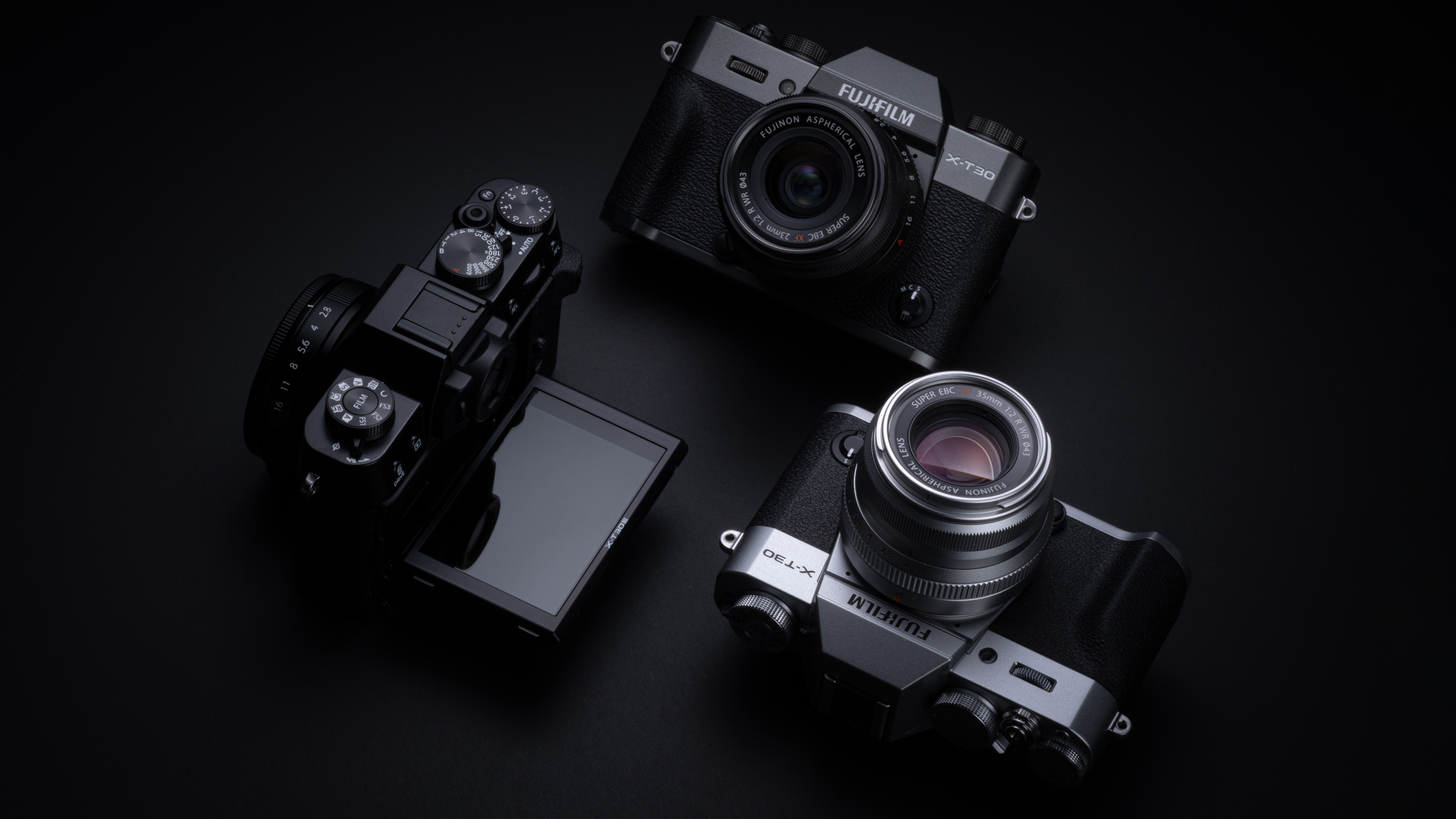 Fujifilm X-T30 III cameras in three colors next to each other on a dark background