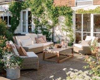 A garden patio with cream and pink sofa set