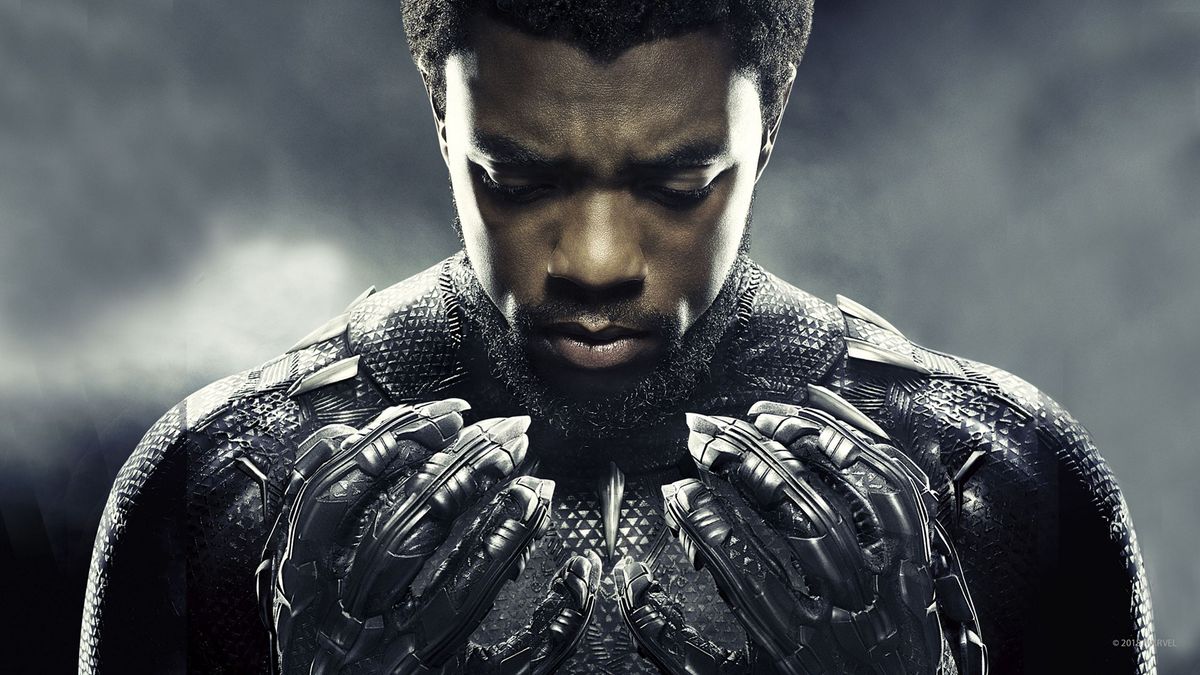 T&#039;Challa stares down at his clawed hands in his superhero suit in a promotional image for Marvel&#039;s Black Panther