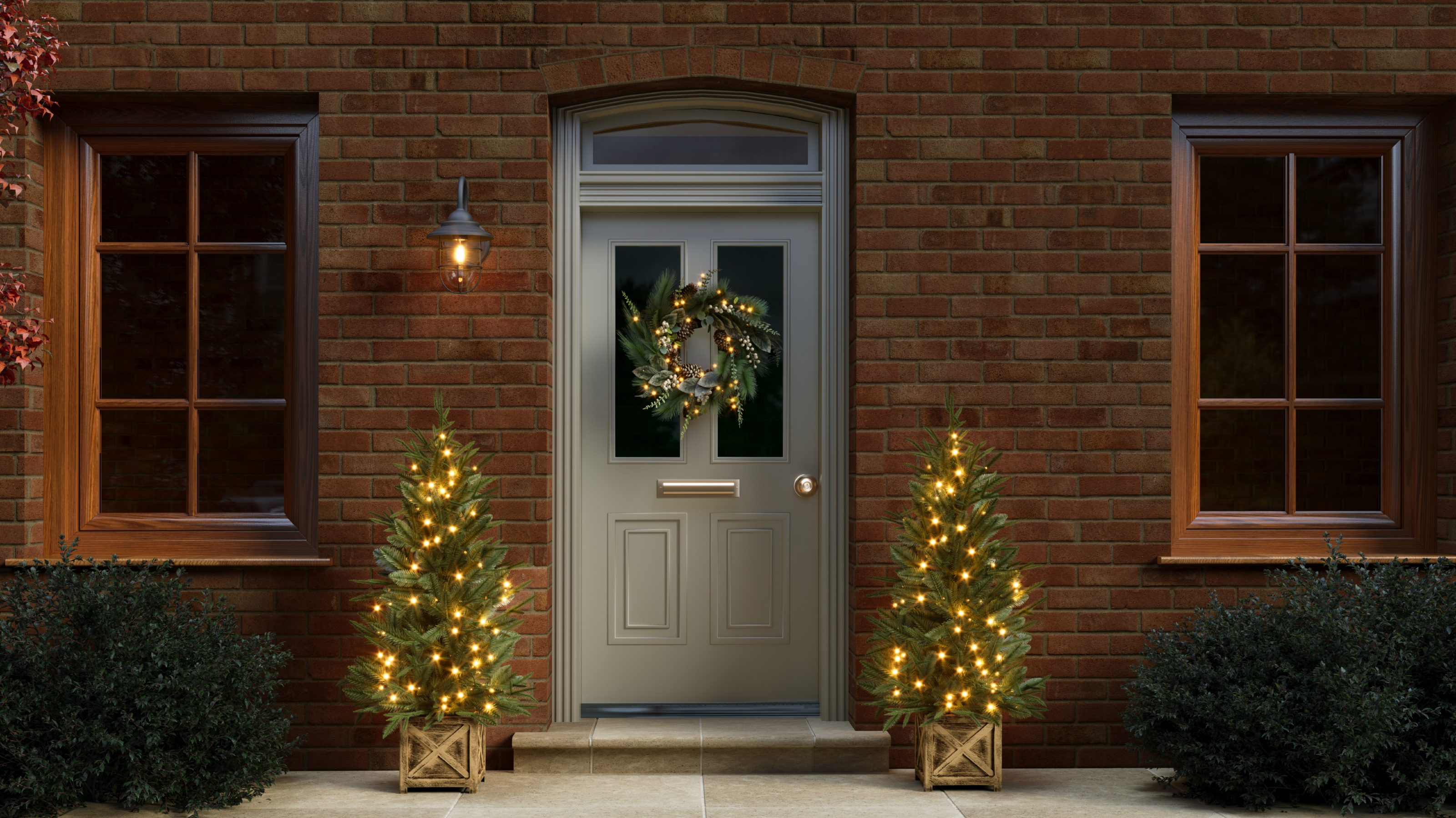 exterior of house with two pre-lit Christmas trees and festive wreath on door 