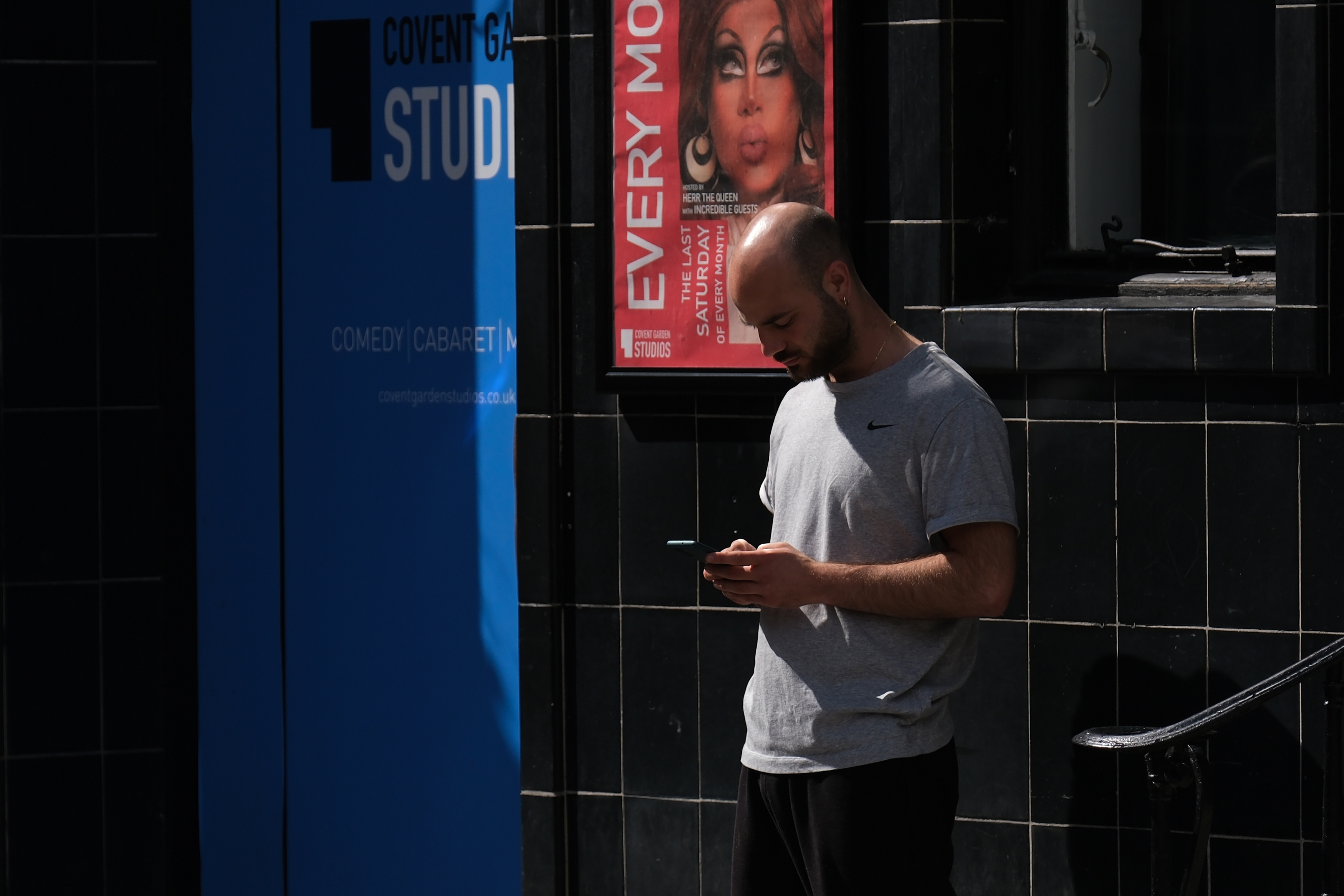 A man looking at his phone on a London street