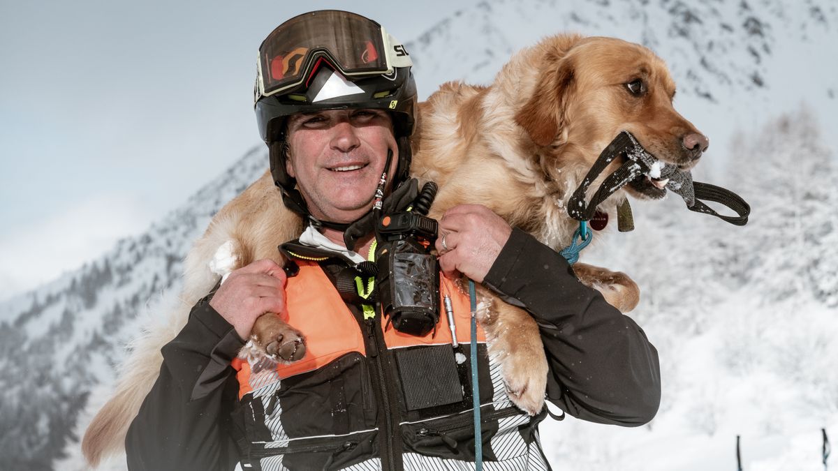 Ski patroller with his dog over his shoulders