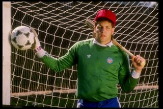 Former USA goalkeeper Tony Meola poses with a football and a baseball bat in 1991.