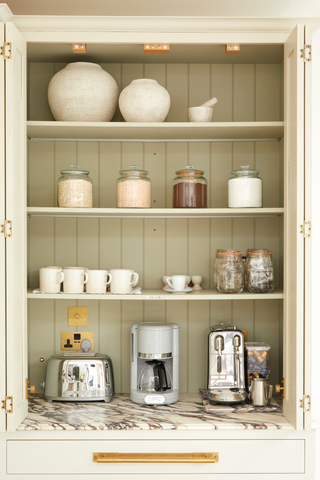 kitchen shelving with stainless steel appliances and mugs