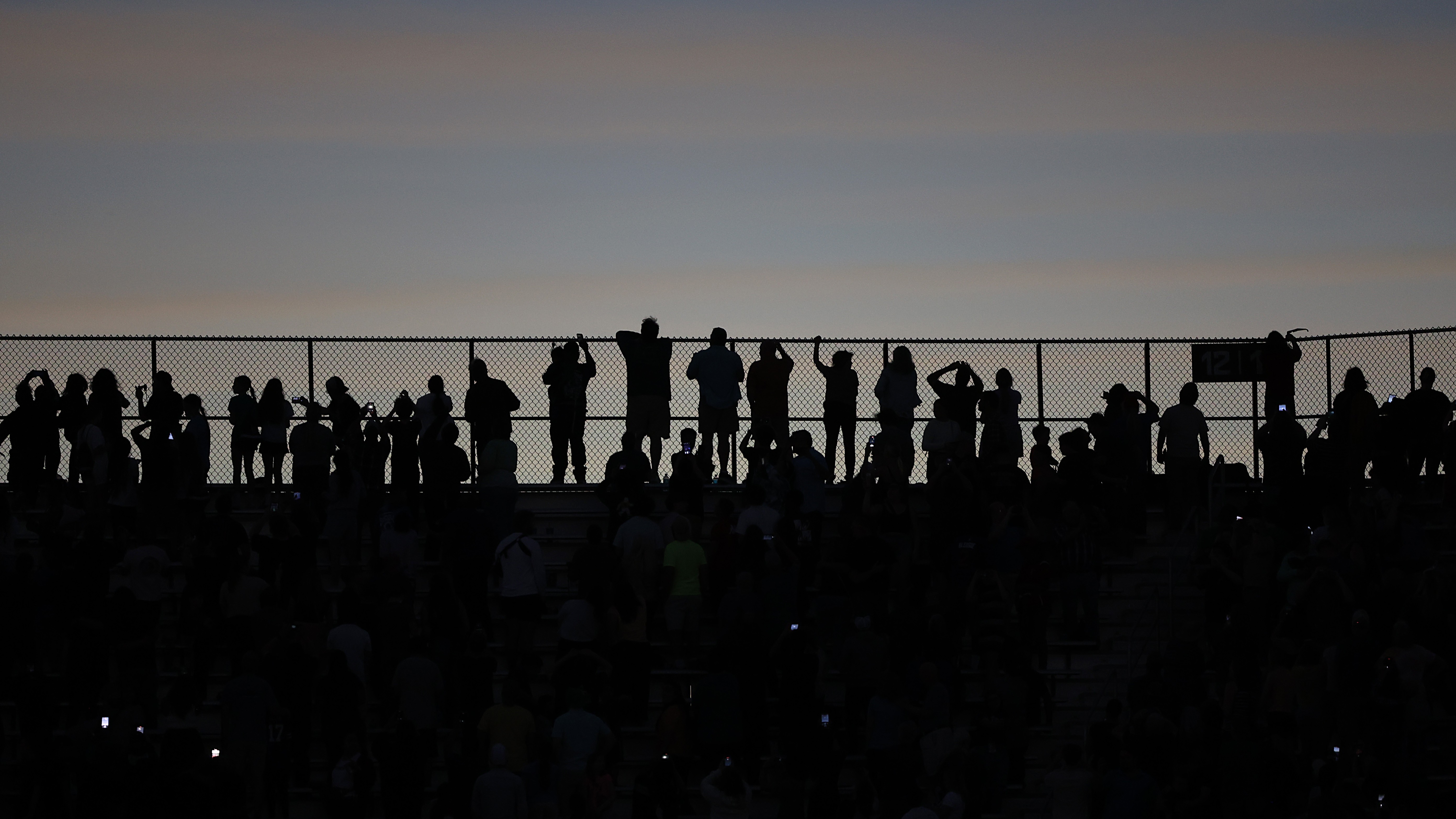 silhouettes of people in darkness during a total solar eclipse