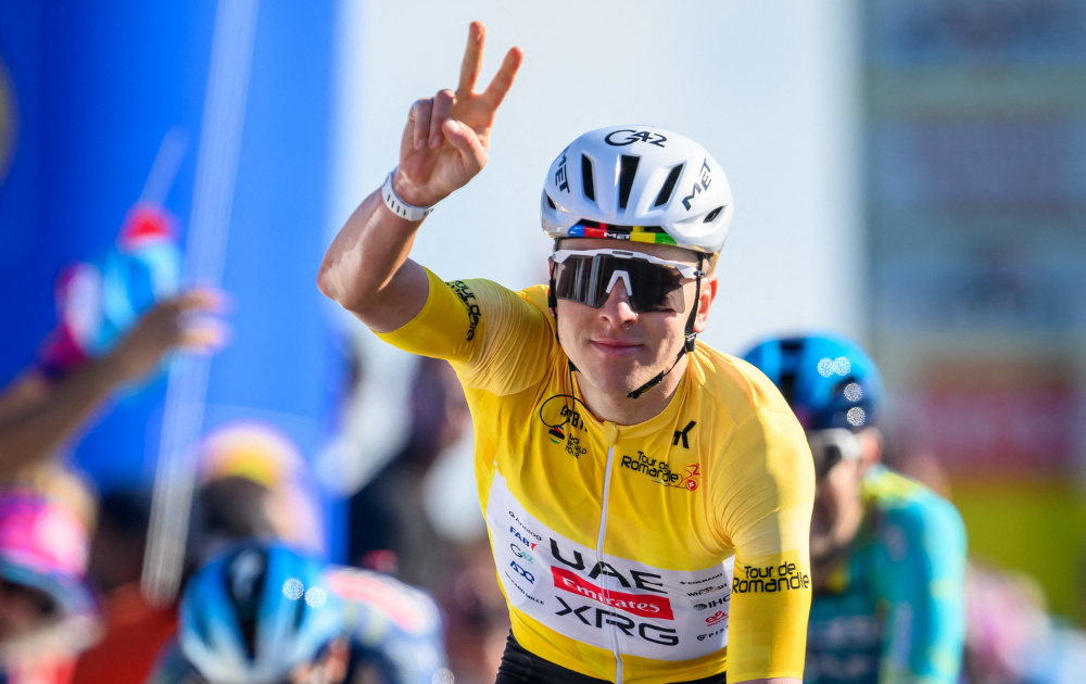 UAE Team Emirates-XRG's Slovenian rider Tadej Pogacar celebrates as he crosses the finish line of the second stage of the Tour of Romandie UCI cycling World tour, 173.1 km from Rue to Vucherens