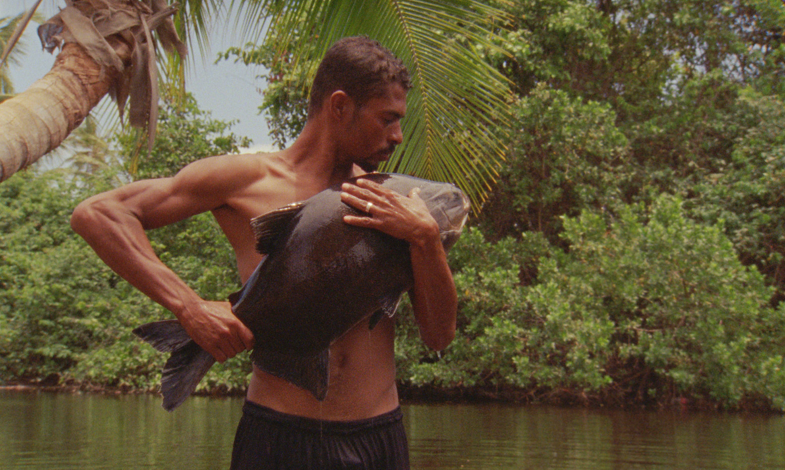 Male holding a very large fish from river