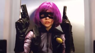 Chloe Grace Moretz taking cover in costume while holding twin handguns in Kick-Ass.