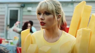 Taylor Swift in red lipstick dressed as a french fry in the music video for "You Need to Calm Down"