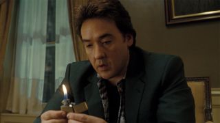 John Cusack holding a lighter in 1408