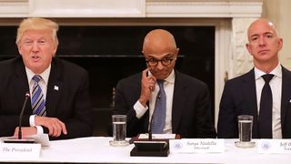 Satya Nadella sits between Donald Trump and Jeff Bezos looking awkward