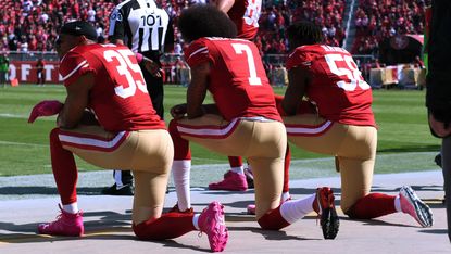 Eric Reid, Colin Kaepernick and Eli Harold kneel for the national anthem