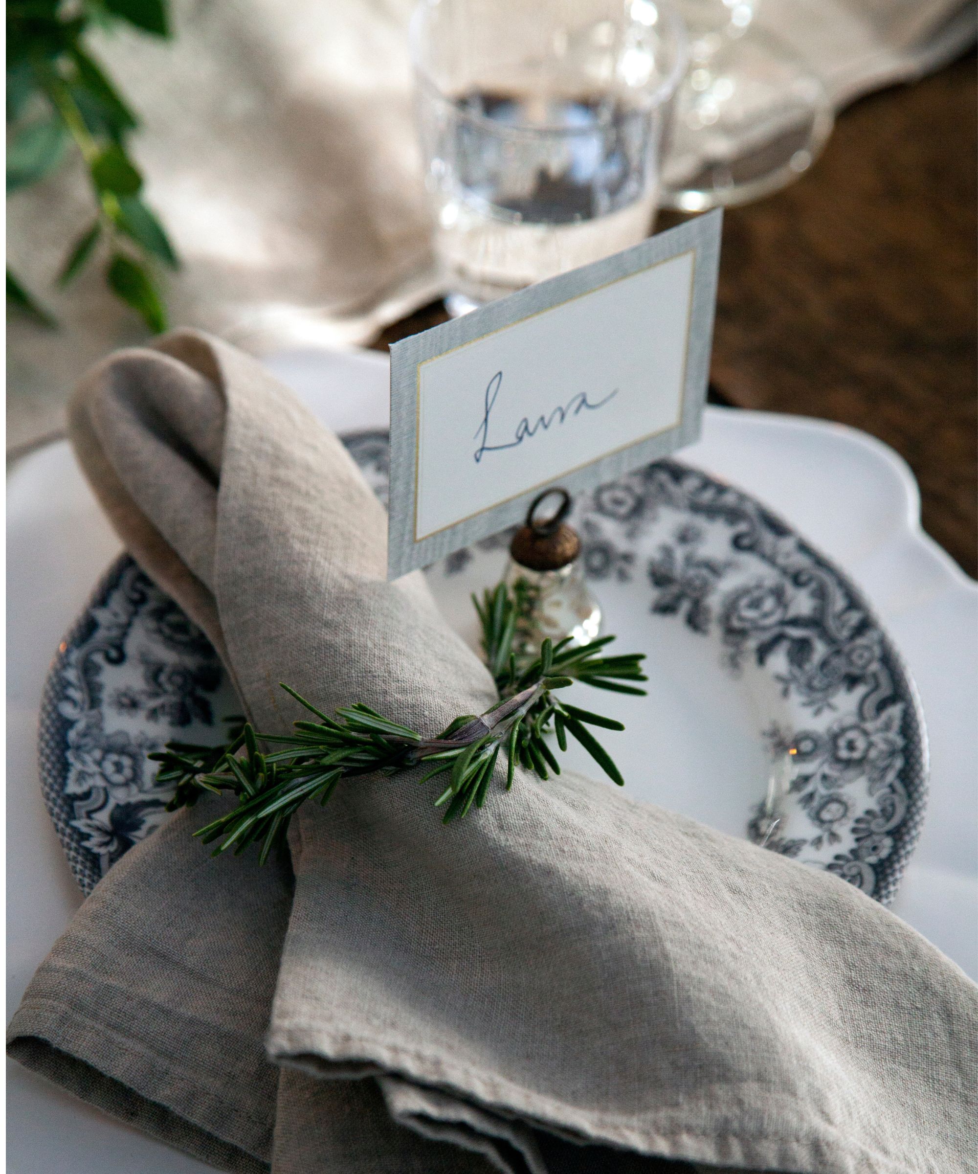 Gray linen napkin with a sprig of rosemary as a napkin ring
