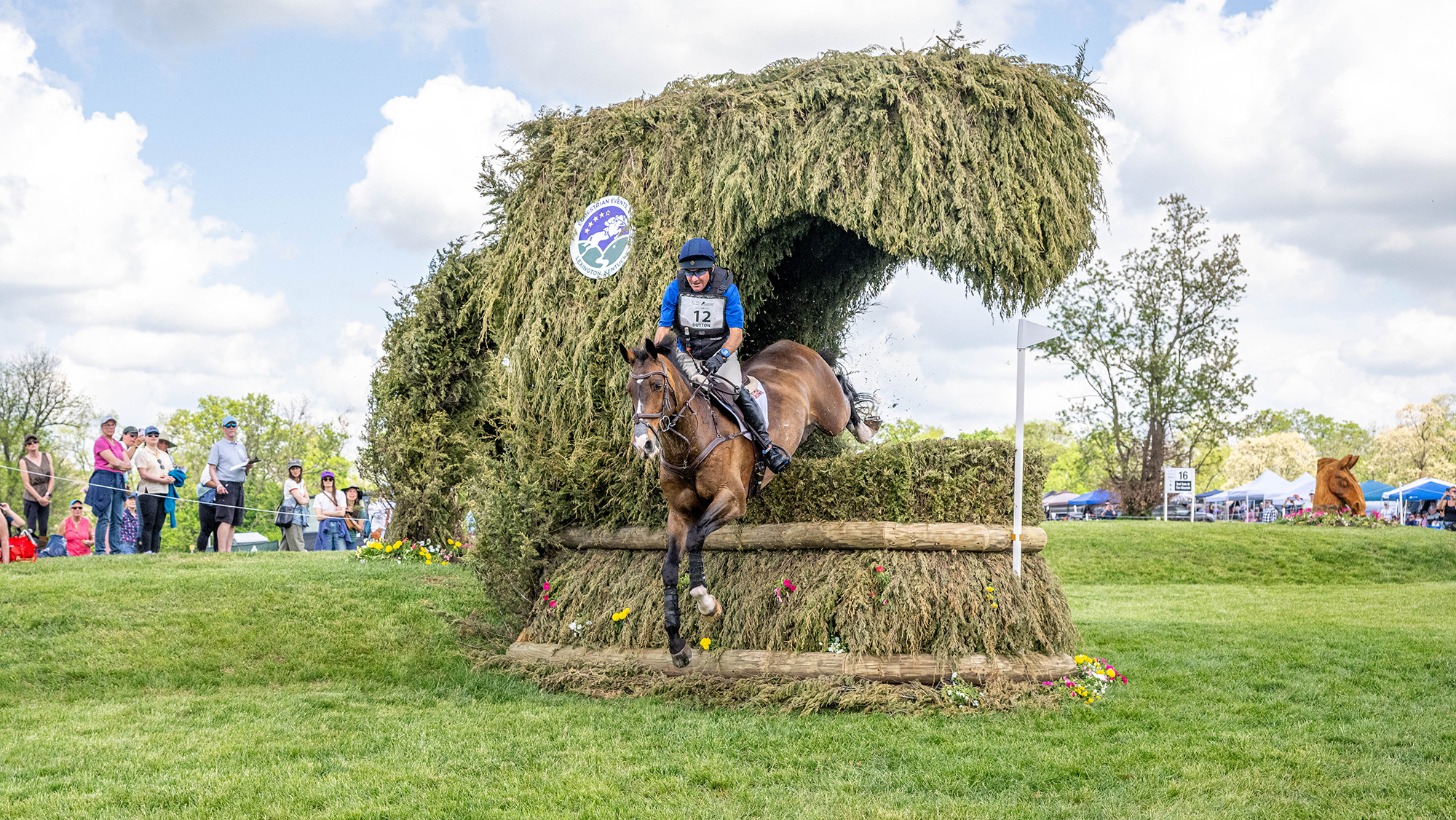 Phillip Dutton and Possante jump a brush fence with a curve of brush over the top of it at Kentucky Three-Day Event 2026