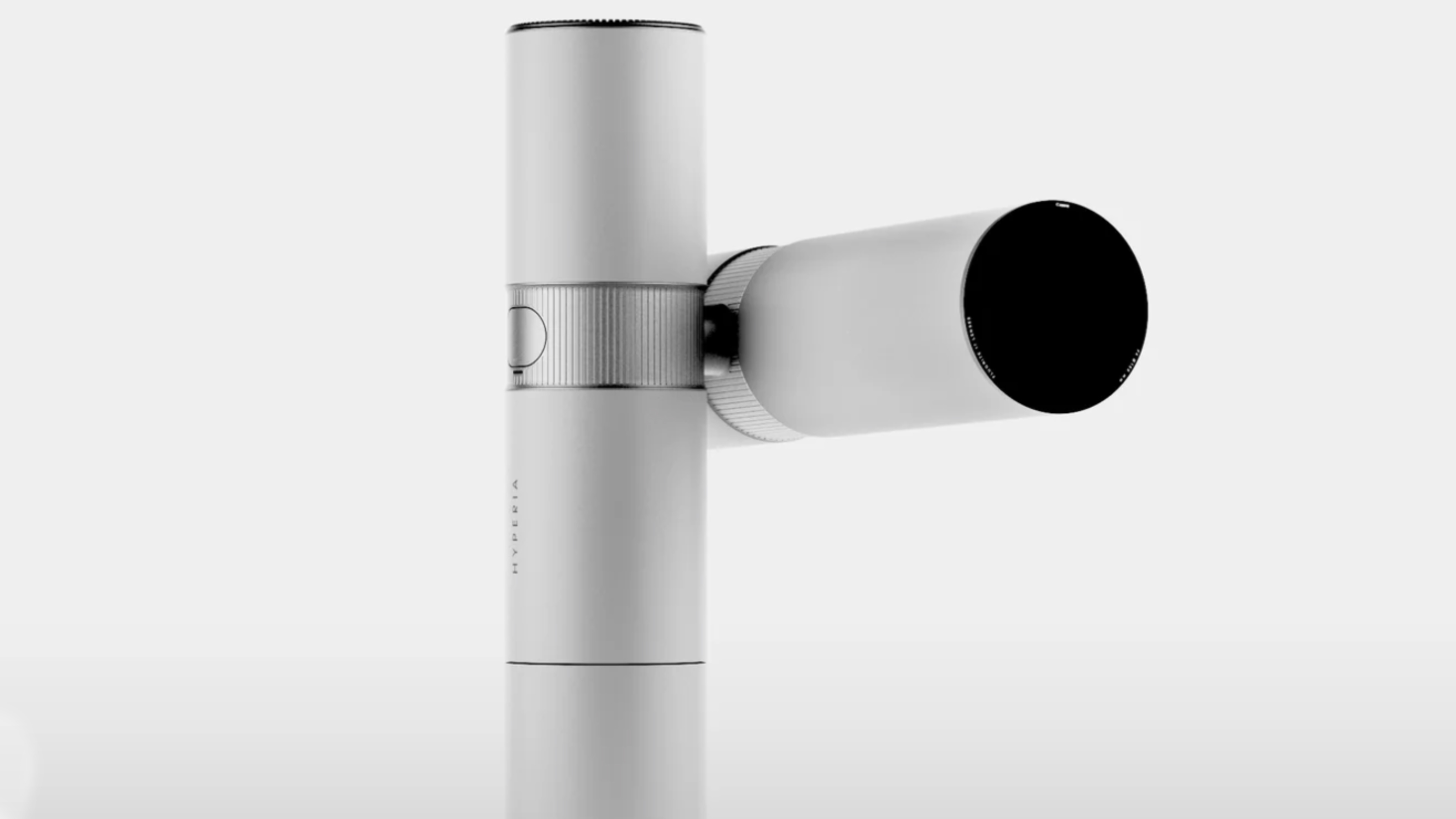 A sleek, modern white telescope mounted on a cylindrical base, angled slightly upward against a neutral background