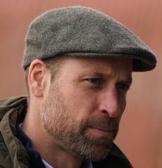 Prince William wearing a flat cap and green coat with a hood