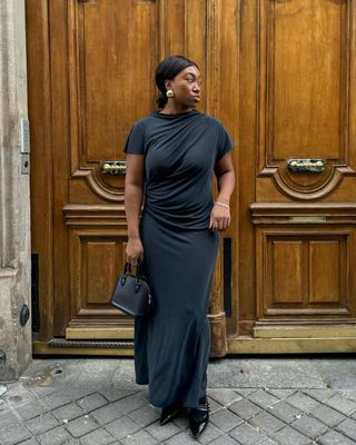 Woman wear black dress, black bag and black heels