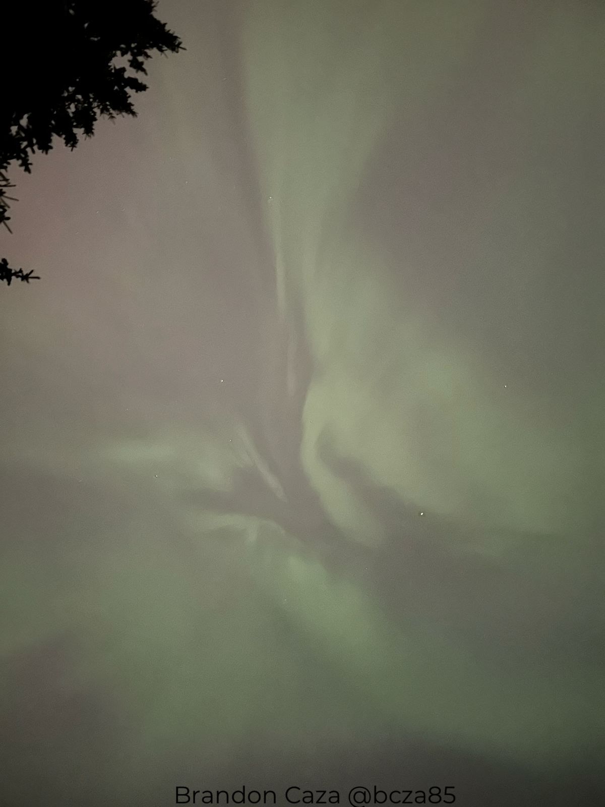green auroras show as ribbons of green light stretching across the sky.