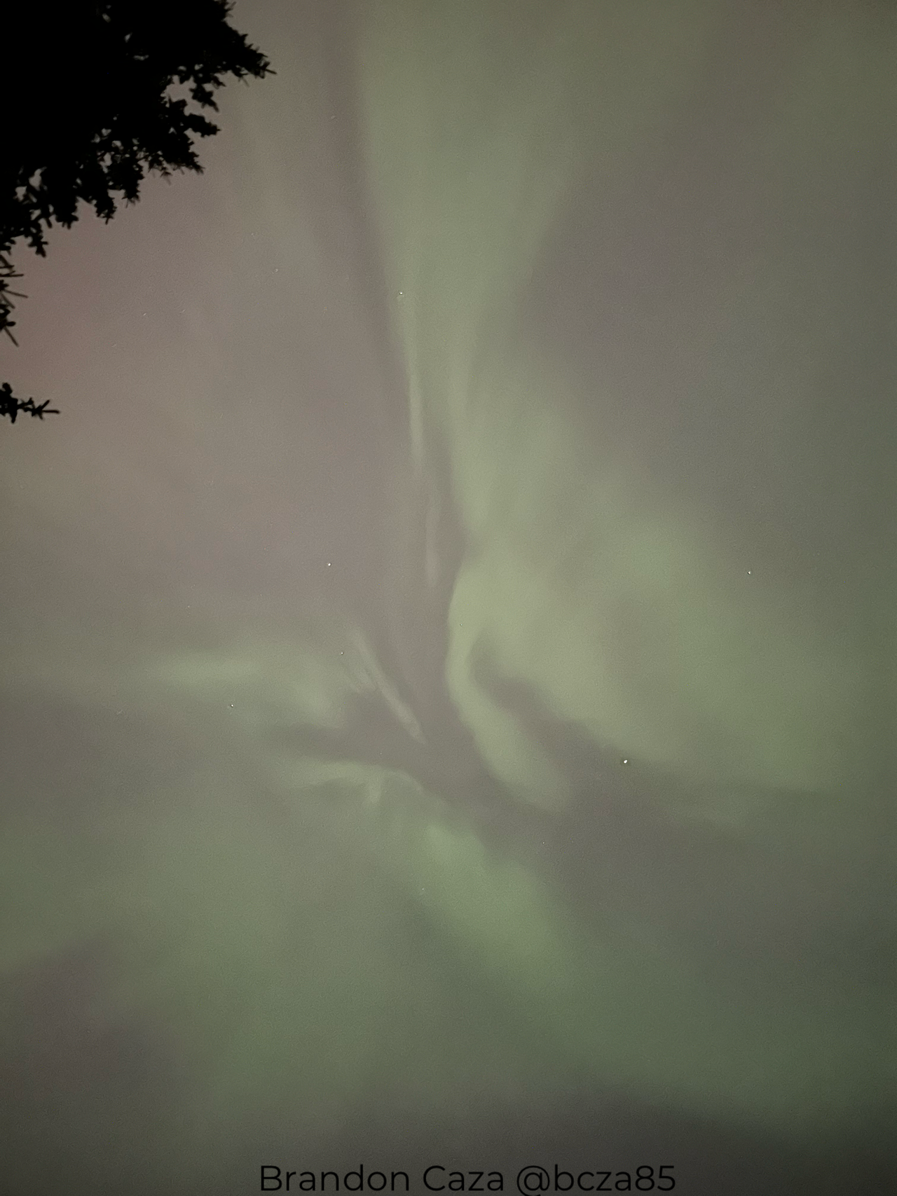 green auroras show as ribbons of green light stretching across the sky.