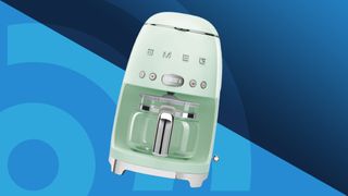 Green Smeg drip coffee maker on blue background