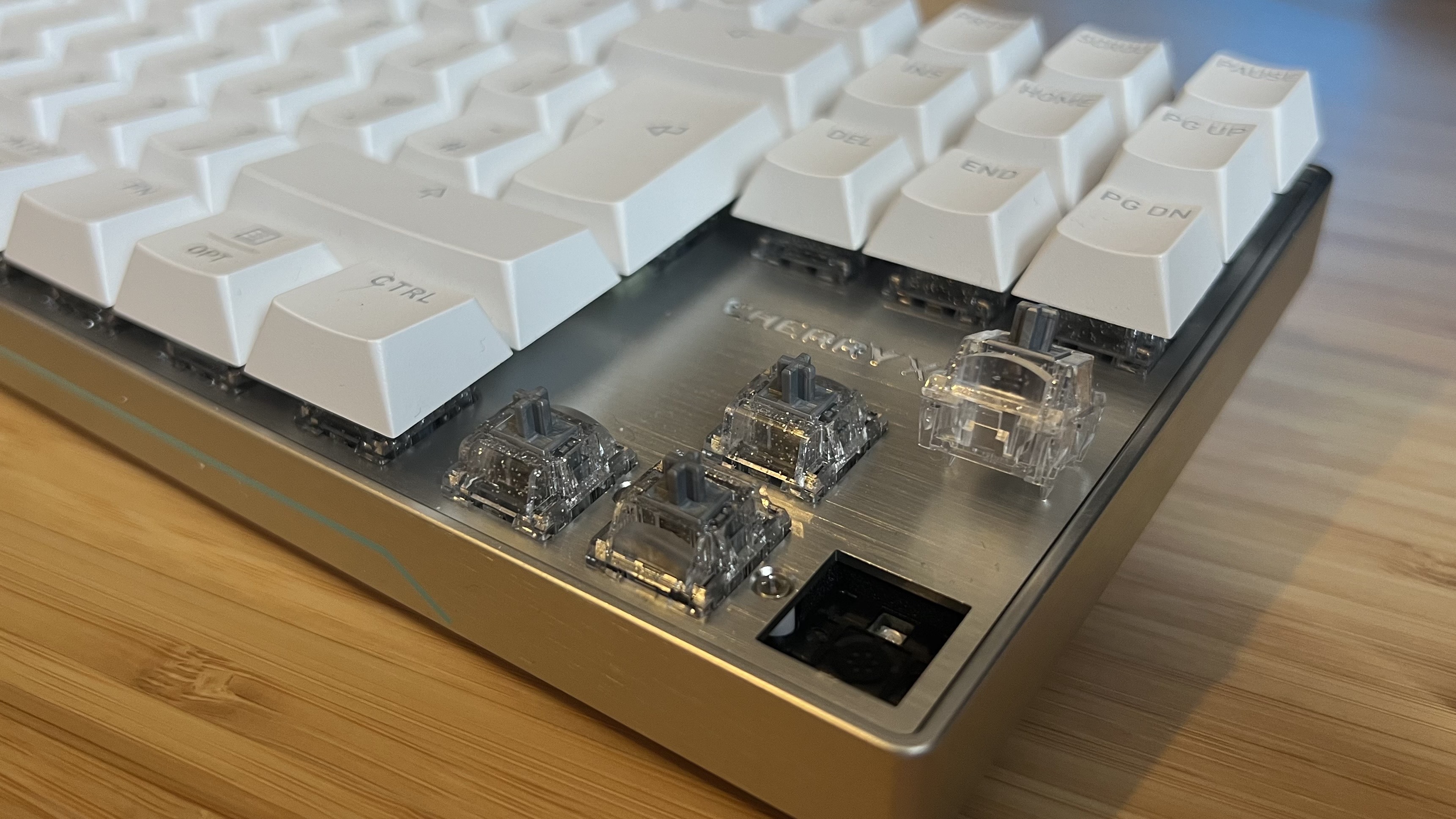 Close up on arrow keys of Cherry XTRFY MX 8.2 Pro TMR Wireless gaming keyboard with keycaps and one switch removed