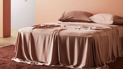 Ettitude Signature Sateen Sheets against a dusty red wall.