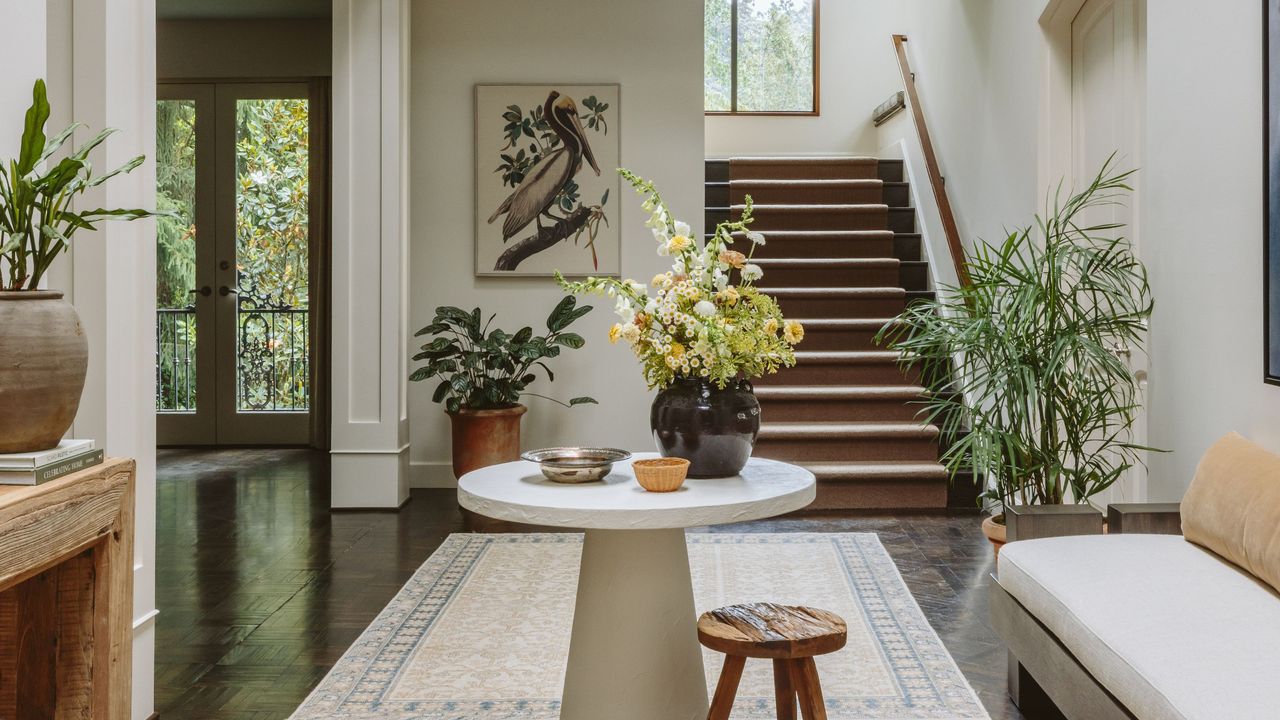 Large entryway with a patterned rug matching the neutral furnishings