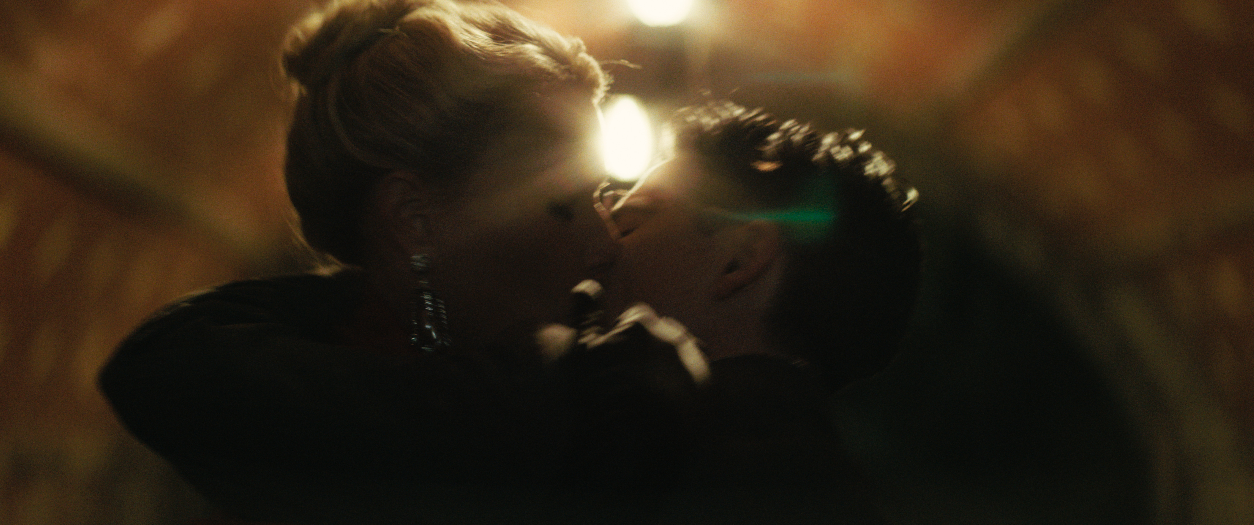 gwyneth paltrow as kay and timothee chalamet as marty kissing under a bridge at night in central park in the movie marty supreme