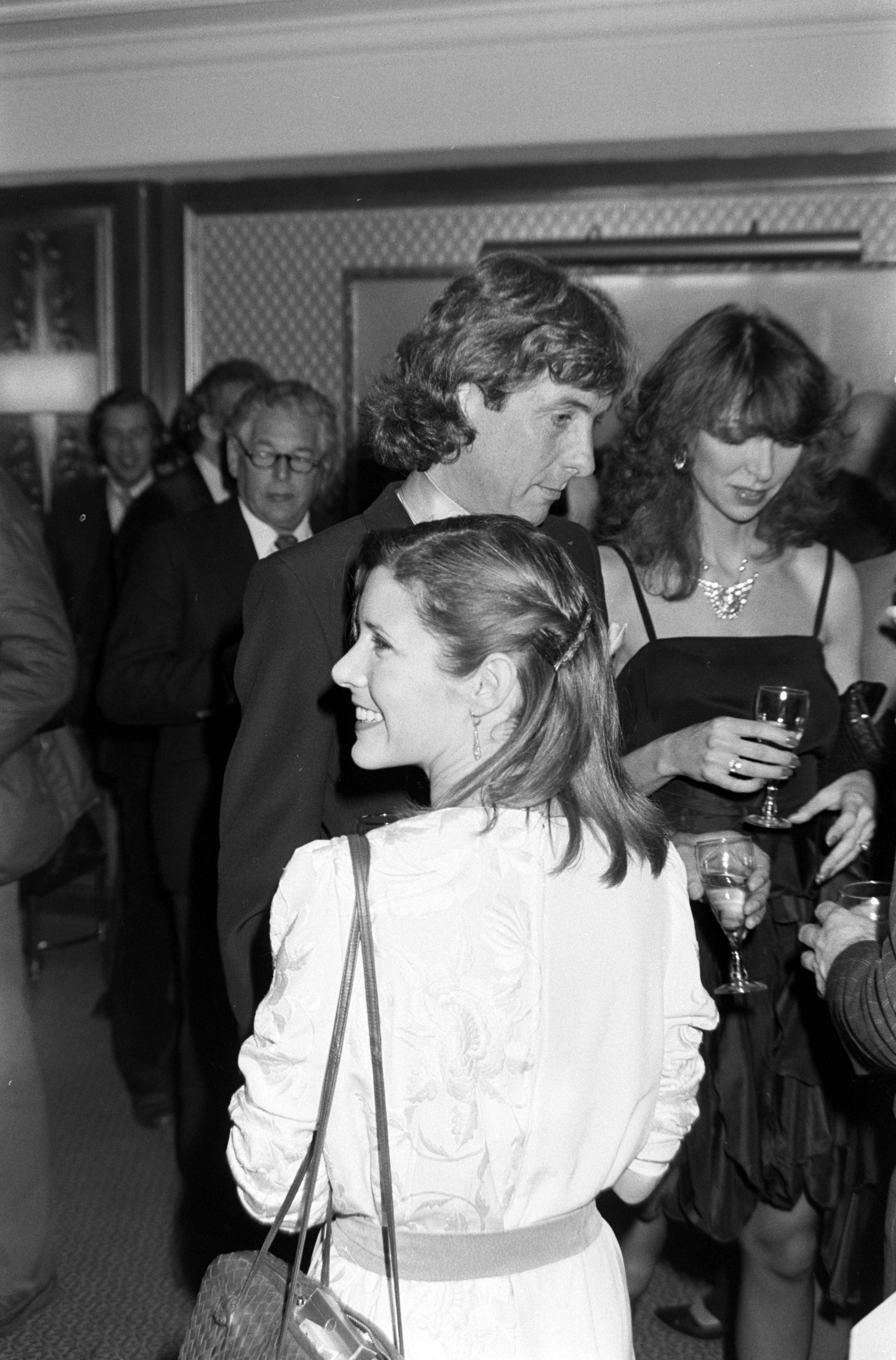 Eric Idle (C, background) and Carrie Fisher (C, foreground) attend a party at 90 Park Lane, a restaurant in London, England, on January 28, 1982.