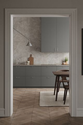 A pale grey kitchen with modern cabinets and delicate tongue and groove texture